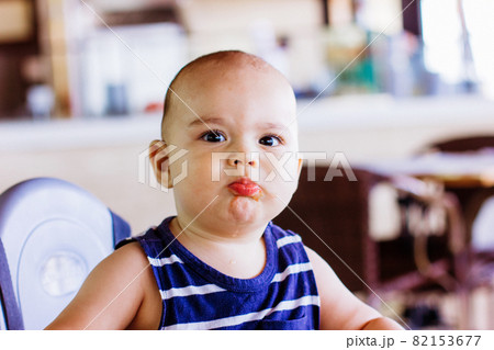 Sweet baby boy sitting at high chair in restaurant. Hotel vacation with child 82153677