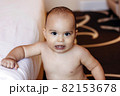 Sweet baby boy near bed in hotel room. Family vacation with children 82153678