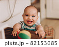 Portrait of cute baby close-up. Sweet little infant looks to camera. Bald baby with brown eyes and long lashes 82153685