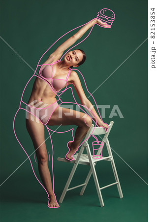 Beautiful young woman with perefect body shape posing isolated over green background. 82153854