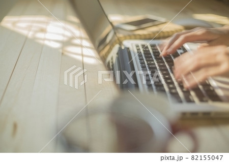 Hand woman fast typing on laptop on wooden desk Hand woman fast typing on laptop on wooden desk 82155047
