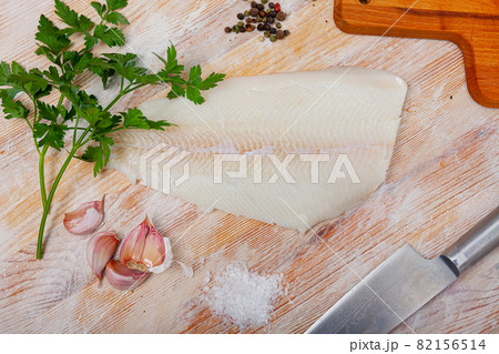 Raw halibut fillet on wooden table 82156514