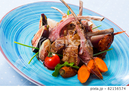 Tasty lamb ribs baked and served with vegetables and fresh figs 82156574