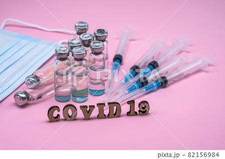Medical ampoules and mask. Syringes and ampoules. Pink background. Injections and medications. 82156984