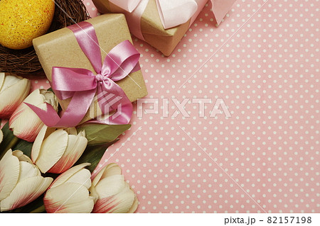 Gift box with roses bouquet with space copy on pink polka dot background 82157198