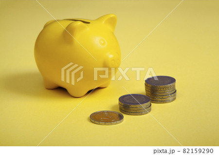 piggy bank with money euros in yellow background piggy bank with money euros in yellow background 82159290