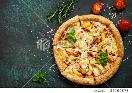 Pizza menu. Delicious traditional Italian pizza Hawaiian on on a dark stone or concrete background. Top view, copy space. Pizza menu. Delicious traditional Italian pizza Hawaiian on on a dark stone or concrete background. Top view, copy space. 82160373