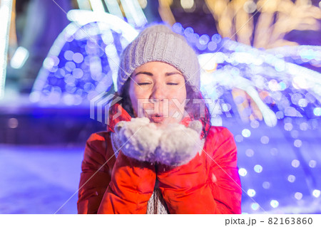 Portrait of young funny attractive woman over snowy Christmas background. Winter holidays and season concept. 82163860