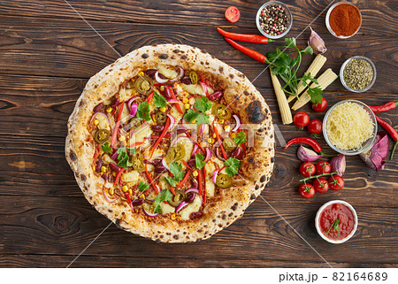 Tradition homemade spicy mexican pizza with chili, beef, onion, jalapeno pepper and ingredients top view on wooden table. Cooking at home concept 82164689