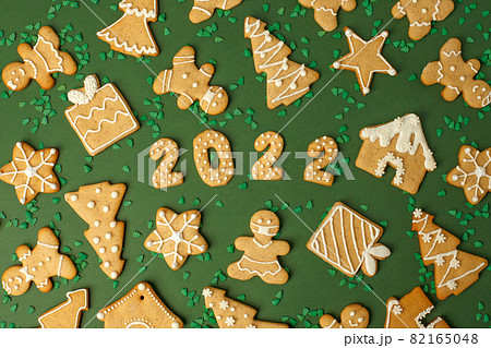 Winter Holiday banner- set of gingerbread on natural green background - Number Happy New Year 2022, house, man in mask, xmas tree sprinkles, Merry Christmas background, trendy concept, flyer 82165048