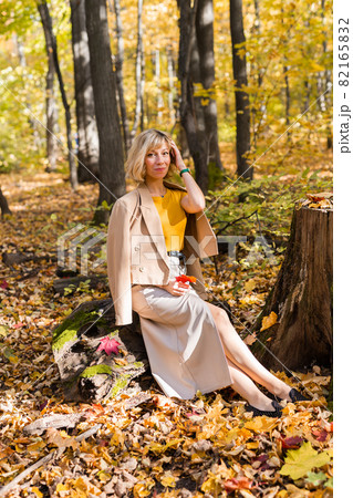 Portrait of beautiful young woman walking outdoors in autumn. Fall season and stylish girl concept. 82165832
