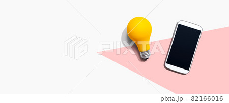 Smartphone with a yellow light bulb Smartphone with a yellow light bulb 82166016