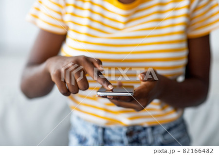 Unrecognizable black woman using brand new mobile phone Unrecognizable black woman using brand new mobile phone 82166482