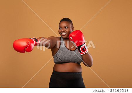 Young Black Woman Boxing Wearing Red Gloves Throwing Punch 82166513
