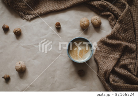 Cup of cappuccino on a brown paper texture background with cozy warm plaid Cup of cappuccino on a brown paper texture background with cozy warm plaid 82166524
