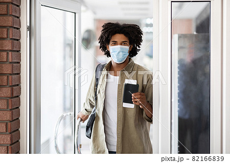 Black Man In Medical Mask Holding Passport With Tickets And Entering Building 82166839
