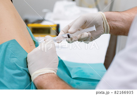 Orthopedic doctor injecting cortisone in slipped disc 82166935