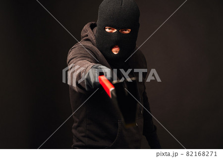 Burglar holding metallic crowbar on black background 82168271