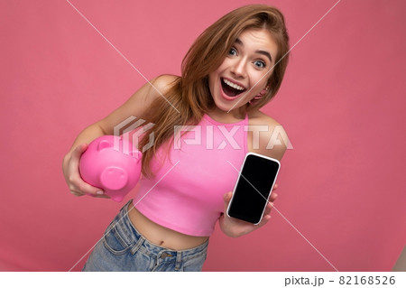 Surprised beautiful happy young woman wearing casual outfit isolated over background with empty 82168526