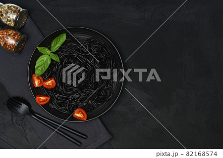 Black pasta set with tomato, basil and seasonings. Black pasta set with tomato, basil and seasonings. 82168574