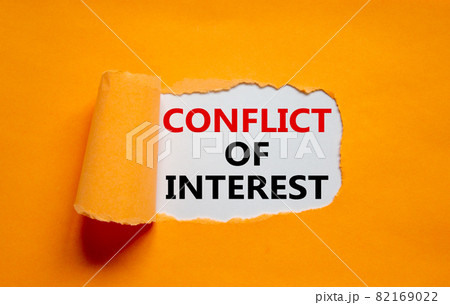 Conflict of interest symbol. Words 'Conflict of interest' appearing behind torn orange paper. Beautiful orange background. Business, conflict of interest concept, copy space. 82169022