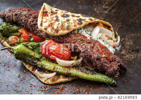 Traditional adana kebap on a skewer with tomato and yogurt 82169065