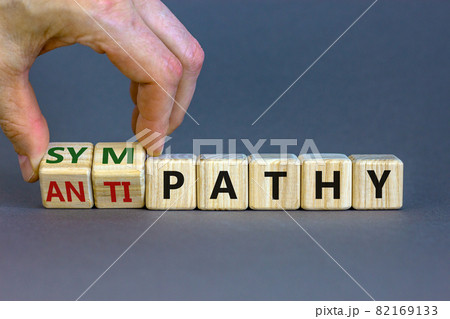 From antipathy to sympathy. Businessman turns cubes and changes the word 'antipathy' to 'sympathy'. Beautiful grey background. Copy space. Psychological and antipathy or sympathy concept. 82169133
