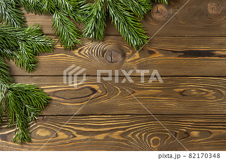 Christmas background. Nobilis fir branches, twigs on brown wooden planks. Copy space, flat lay, top view. Holiday, Xmas, New Year, sales, delivery concept, layout with place for text. Horizontal 82170348