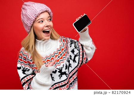 Photo of attractive smiling young blonde woman wearing warm knitted hat and winter warm sweater Photo of attractive smiling young blonde woman wearing warm knitted hat and winter warm sweater 82170924