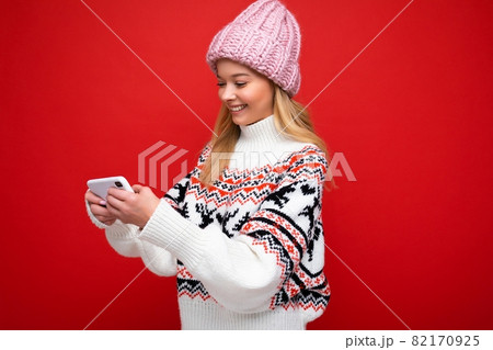 Side-profile Photo of beautiful smiling young blonde woman wearing warm knitted hat and winter warm 82170925