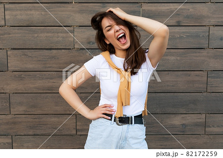 Photo of emotional positive happy joyful pretty young brunette woman in trendy outfit. Beautiful Photo of emotional positive happy joyful pretty young brunette woman in trendy outfit. Beautiful 82172259