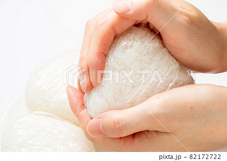 おにぎりを握る。(衛生面への配慮から、ラップを使用して握る。) おにぎりを握る。(衛生面への配慮から、ラップを使用して握る。) 82172722