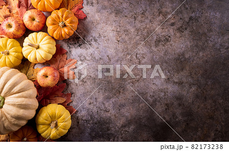 Autumn composition. Pumpkin, autumn leaves and apple on dark stone background. Flat lay, top view with copy space. Autumn composition. Pumpkin, autumn leaves and apple on dark stone background. Flat lay, top view with copy space. 82173238