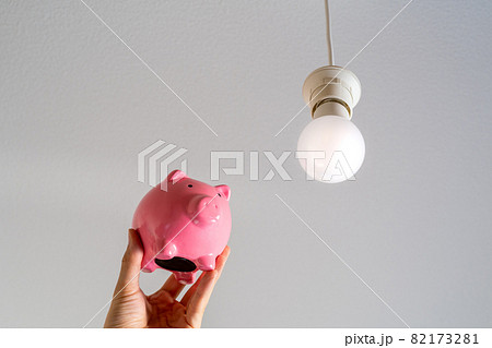 ピンクの豚の貯金箱と天井から吊るされているLED照明 82173281