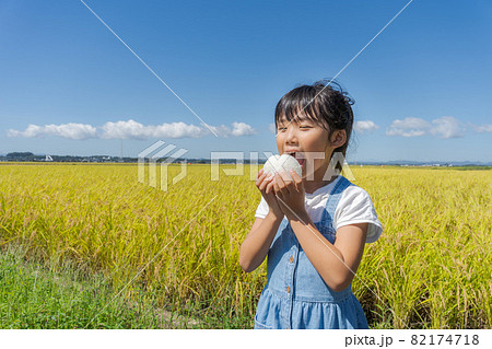 おにぎりを頬張る女の子　 82174718