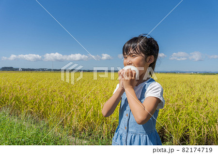 おにぎりを頬張る女の子　 82174719