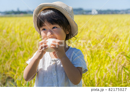 おにぎりを頬張る女の子 おにぎりを頬張る女の子 82175027