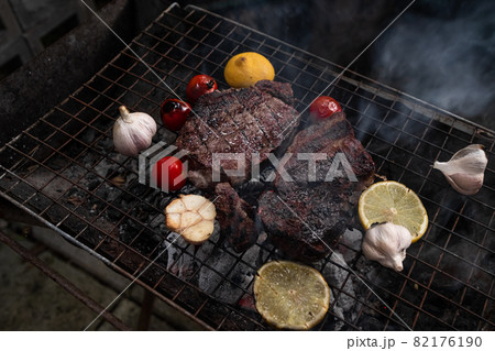 Vegetables and meat on the grill on hot coals with smoke Vegetables and meat on the grill on hot coals with smoke 82176190