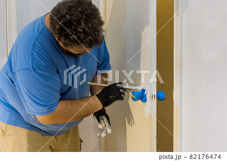 Contractor master processes painting for painting wooden doors with using paintbrush Contractor master processes painting for painting wooden doors with using paintbrush 82176474