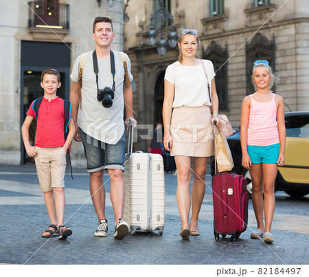Smiling parents with children walking together on city 82184497