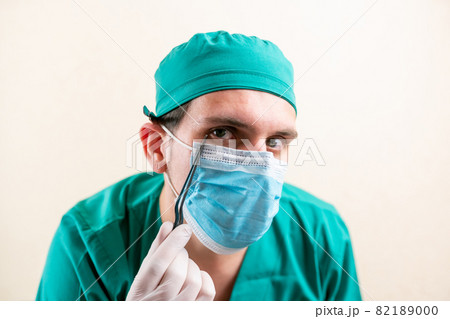 Doctor ENT, wearing a mask and glasses, with a device in his hands. 82189000