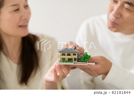 住宅模型を持つシニア夫婦 手元 住宅模型を持つシニア夫婦 手元 82191844