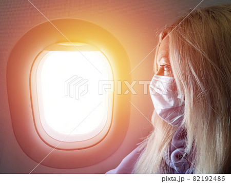 Woman wearing medical protective mask in airplane while flight. New normal travel during covid-19 pandemic situation 82192486