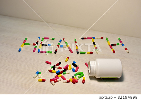 Pills in capsules in the form of the text Health on a table. Pills in capsules in the form of the text Health on a table. 82194898