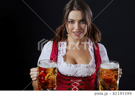 Oktoberfest server holding beer and smiling Oktoberfest server holding beer and smiling 82195399