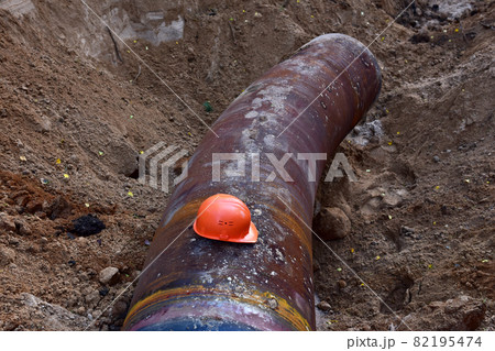 Safety helmet on a pipe in a trench during the construction of pipeline. Safety helmet on a pipe in a trench during the construction of pipeline. 82195474