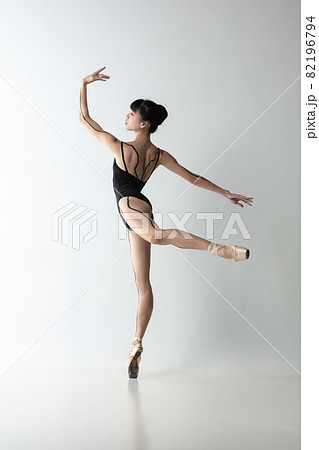 Full-length portrait of graceful ballet dancer, ballerina dancing isolated on light gray studio background. Art, motion, action, flexibility, inspiration concept. Full-length portrait of graceful ballet dancer, ballerina dancing isolated on light gray studio background. Art, motion, action, flexibility, inspiration concept. 82196794
