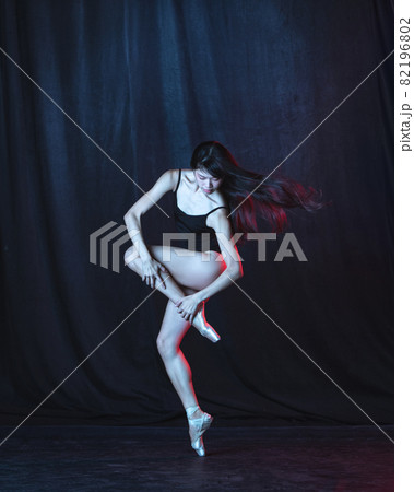 Young and graceful female ballet dancer in motion isolated on dark background in neon light. Art, motion, action, flexibility, inspiration concept. Young and graceful female ballet dancer in motion isolated on dark background in neon light. Art, motion, action, flexibility, inspiration concept. 82196802