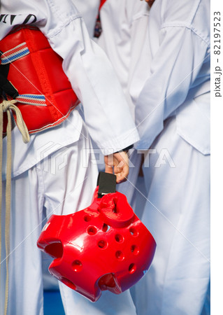 Taekwondo athlete in white uniform with armour and helmet Taekwondo athlete in white uniform with armour and helmet 82197523
