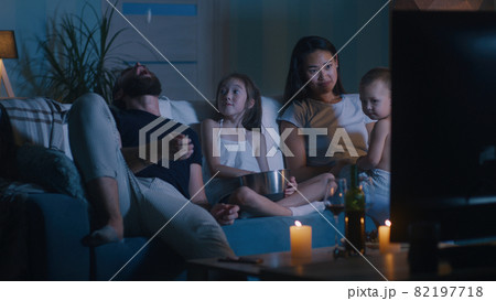 Diverse family watching movie in dark living room 82197718